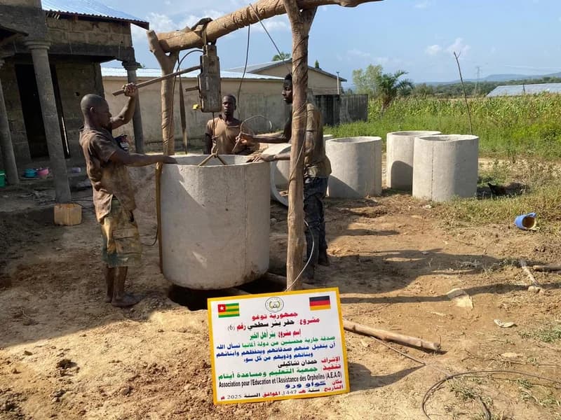 Arbeiter beim Einbau der Betonringe für den Brunnen (Togo)