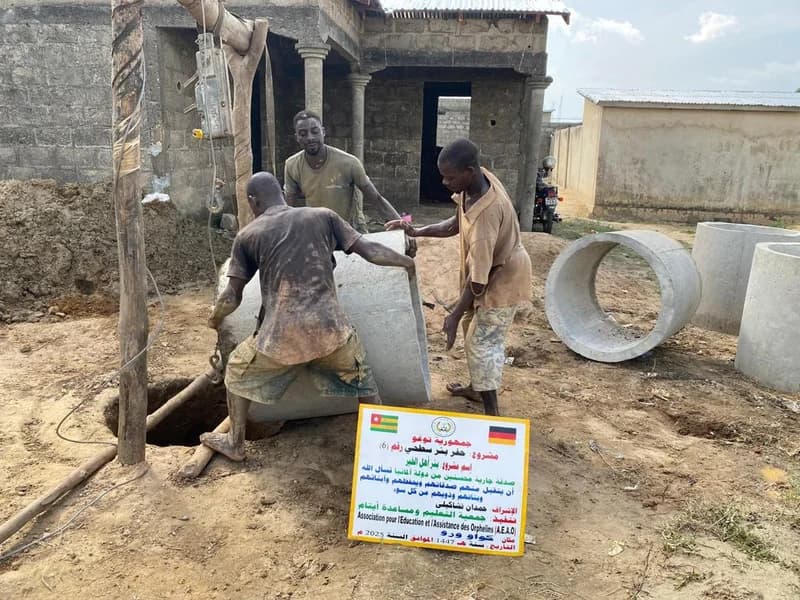 Fertiggestellter blauer Brunnen mit Kindern (Togo)