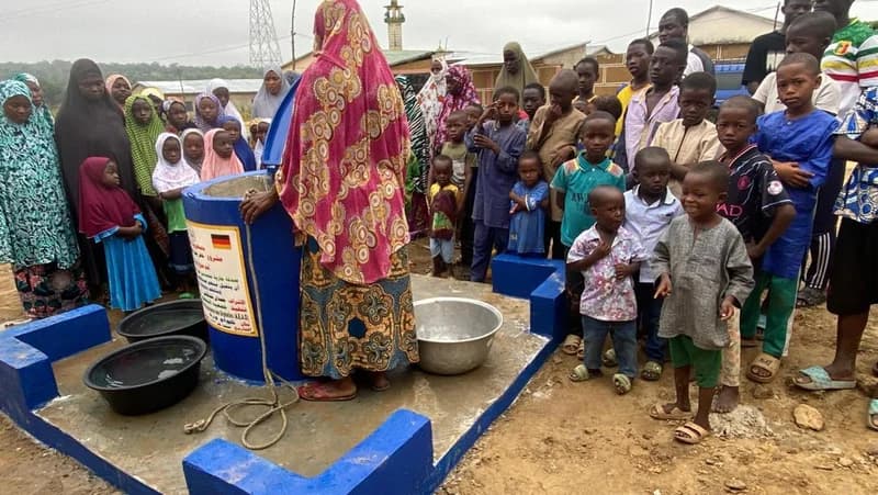 Kinder und Gemeinde am fertigen blauen Brunnen (Togo)