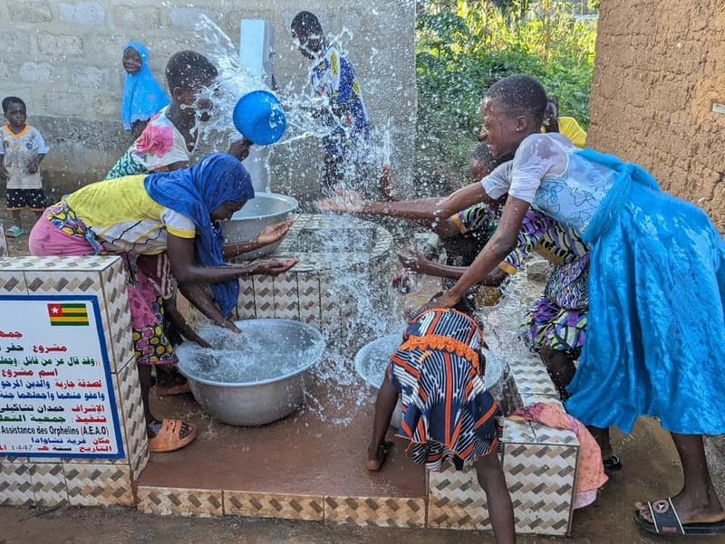 Frauen schöpfen Wasser — Freude und Leben am Brunnen (Togo)